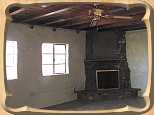 Woodburning fireplace in the living room, with two nice windows facing onto the private eastern courtyard.